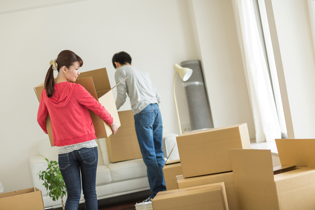 引っ越しの段ボールを運ぶ人