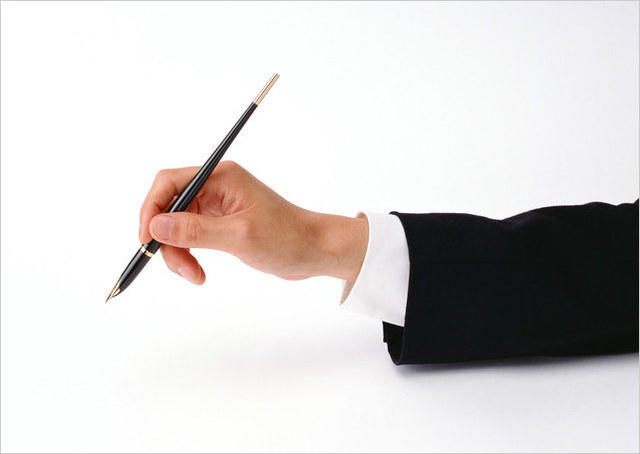 ペンを持つ男性の右手の写真