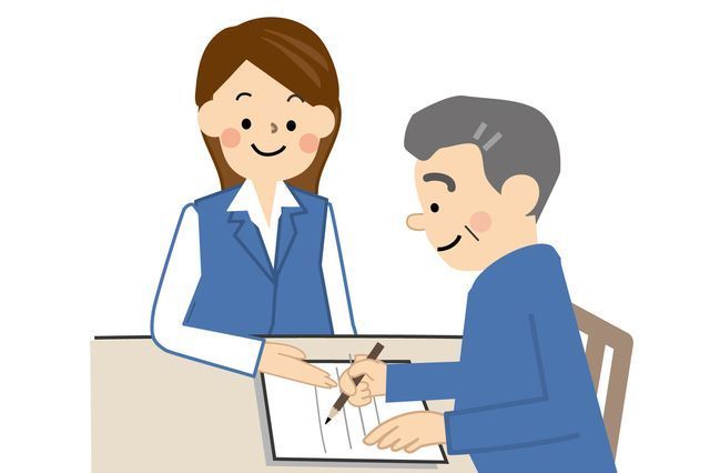 書類を書いている男性と見守る女性