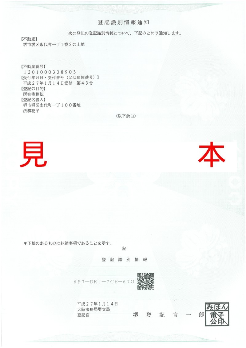 登記識別情報通知の見本（旧様式・目隠しシール式）｜A4緑色の用紙で、下部に12桁符号を覆うシールが貼られていた様式