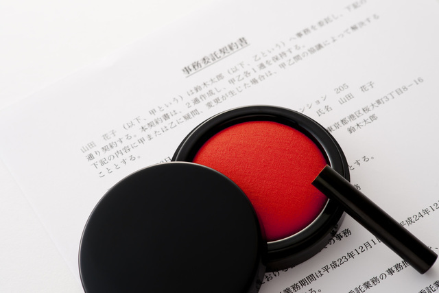 印鑑、朱肉と契約書の写真
